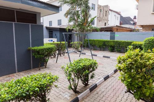 a patio with a table and trees and bushes at Comfortable, Cozy & Homely 4-bedroom duplex in Ikeja