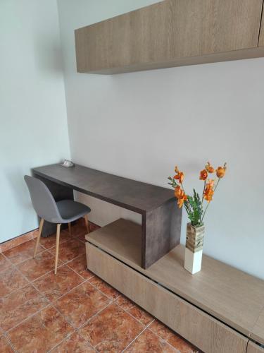 a desk with a chair and a vase with flowers at Mari's By The Sea in Mangalia