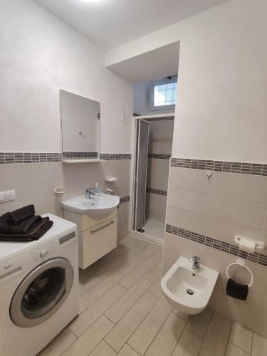 a bathroom with a washing machine and a sink at le case di nonna Piera in Lecco