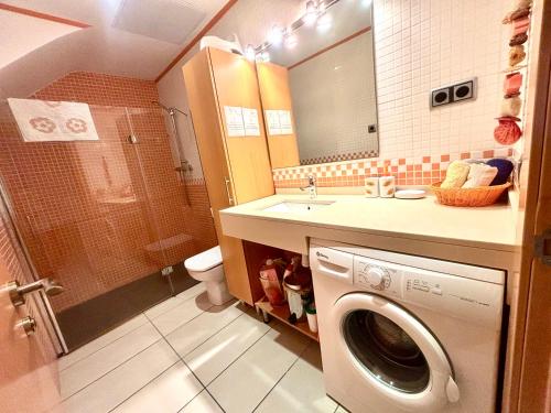 a bathroom with a washing machine and a sink at Increíble casa frente al mar , planta baja in Torredembarra