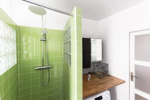 une salle de bain verte avec une douche et un lavabo dans l'établissement Le Canal Flat de Pantin, à Pantin