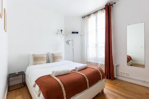 une chambre avec un grand lit blanc et une fenêtre dans l'établissement Le Canal Flat de Pantin, à Pantin