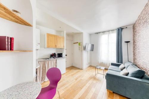 un salon avec un canapé bleu et une cuisine dans l'établissement Le Canal Flat de Pantin, à Pantin