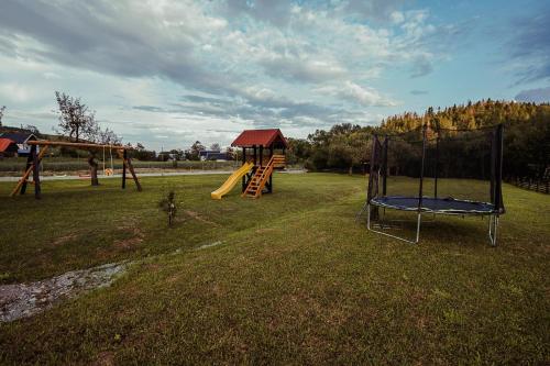 a playground with two swings and a slide at Casa din Valea Bucovinei in Valea Moldovei
