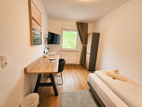 a small room with a desk and a bed at Hike Inn Hotels by Emmerich in Winningen