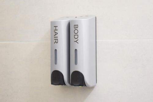 a white toothbrush holder hanging on a wall at Hike Inn Hotels by Emmerich in Winningen