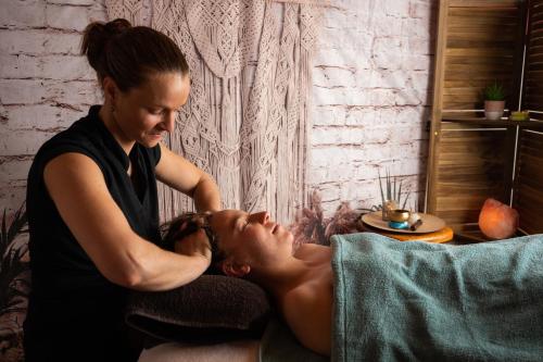 a woman is fuelling a mans face in a room at Hotel le Cinq Hyper - Centre in Chambéry