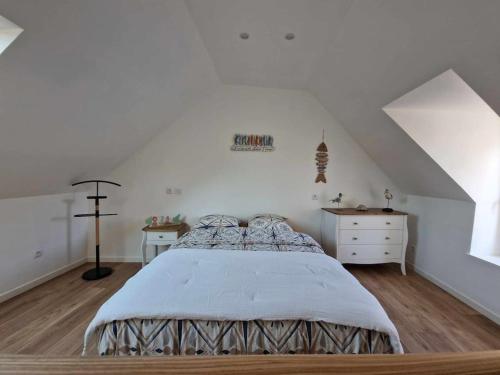 una camera bianca con letto e cassettiera di La citadine boulonnaise a Boulogne-sur-Mer