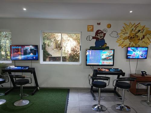 a waiting room with stools and monitors on the wall at Cabañas DELUXE DUNAS DEL ESTE in Punta Colorada