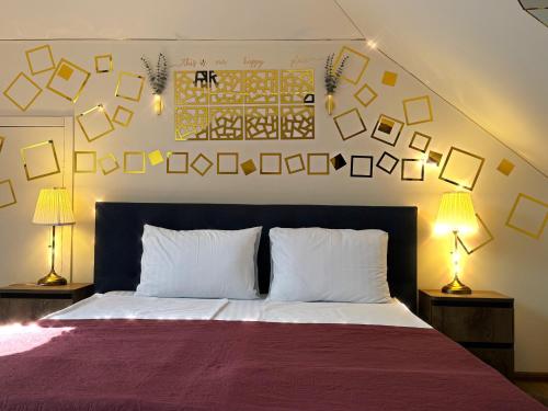 a bedroom with a bed with two lamps and pictures on the wall at SIGNEEV'S Villa in Kyiv