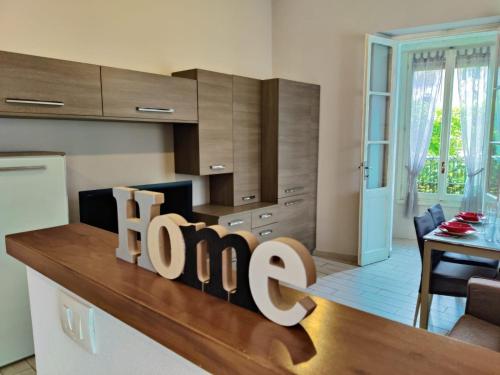 a kitchen with a counter with a sign that says home at le case di nonna Piera in Lecco