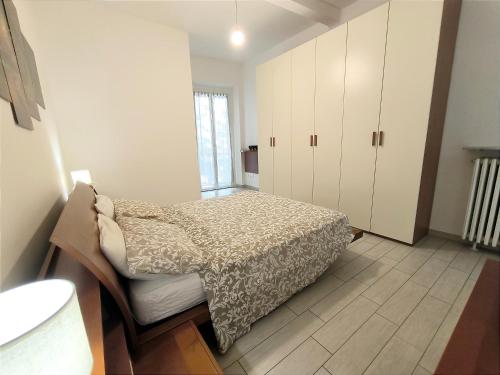 a bedroom with a bed and white cabinets at le case di nonna Piera in Lecco