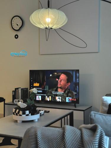 a living room with a tv and a table at The Apple Residence By Heystay Management in Melaka