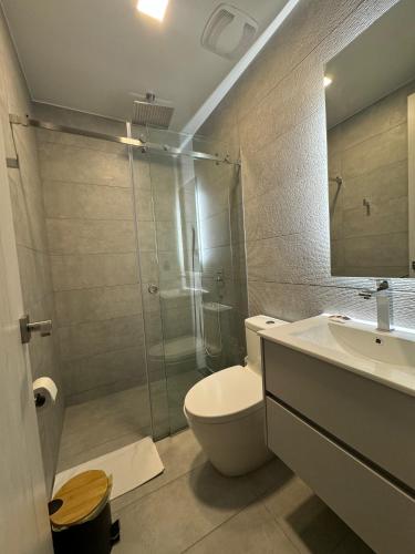 a bathroom with a toilet and a sink and a shower at Nuevo Studio- Piso 17 Vista La Carolina - Edificio Harmony in Quito