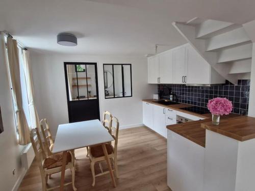 une cuisine et une salle à manger avec une table et des chaises dans l'établissement Maison de pêcheurs entièrement rénovée, à Saint-Pierre-en-Port