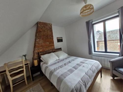 une chambre avec un grand lit et une chaise dans l'établissement Maison de pêcheurs entièrement rénovée, à Saint-Pierre-en-Port