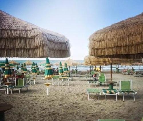 un mucchio di sedie e ombrelloni su una spiaggia di Al mare da Ersy a Montesilvano