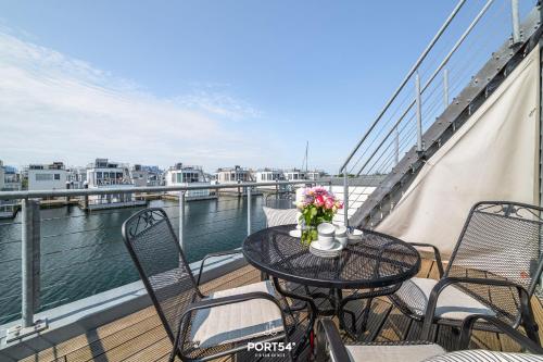 a table on a balcony with a view of the water at Ferienhaus Key West Olpenitz in Olpenitz