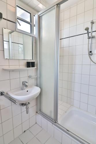 a bathroom with a shower and a sink at Friesenhof - Wohnung A Weener in Weener