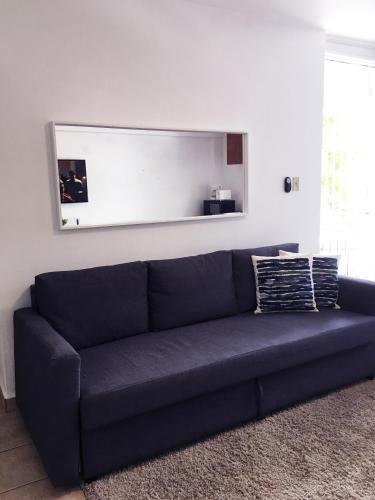 a blue couch in a living room with a mirror at Boulevard Park IV 302 in Mayaguez