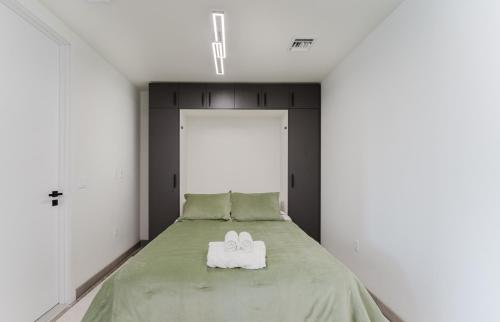 a bedroom with a bed with two white shoes on it at Luxe Apartment in Prime Location in Fort Lauderdale
