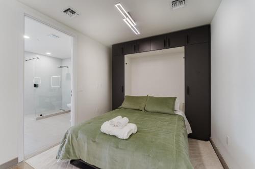 a bedroom with a bed with two towels on it at Luxe Apartment in Prime Location in Fort Lauderdale