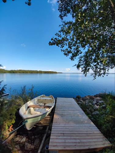 a boat tied to a dock on a lake at Holiday Home Amero purnu 5 in Kolinkylä