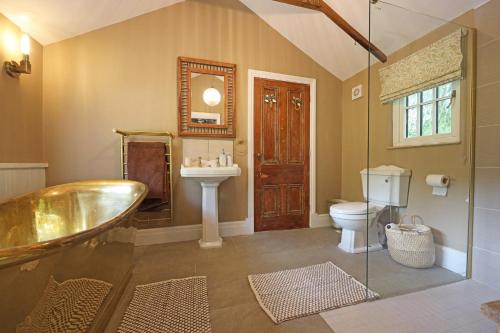 a bathroom with a tub and a sink and a toilet at The Old Chicken Shed in Stafford