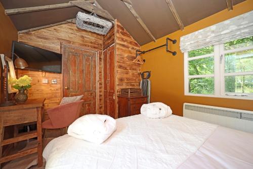 a bedroom with a bed and a desk and a television at The Old Chicken Shed in Stafford
