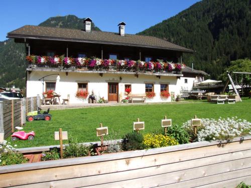 a house with flowers in front of it at Aussermahrhof - familyfarm in Gsies