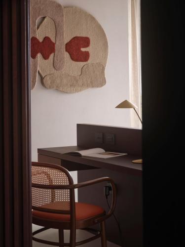 a desk with a chair next to a desk with a sign at Capitolo Riviera in Genova