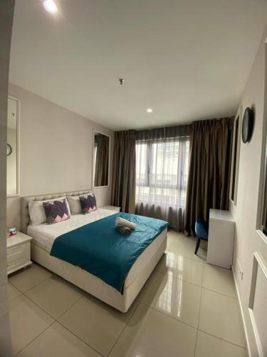 a bedroom with a large bed with a blue blanket at Host Assist Homestay by HA i-City in Shah Alam