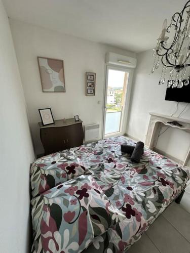 une chambre avec un lit avec une couette fleurie dans l'établissement L'appart Côté Sud, à Istres