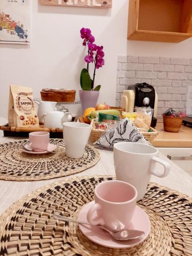 a kitchen counter with cups and saucers on a table at LA MURGIA casa vacanze B&B in Grumo Appula