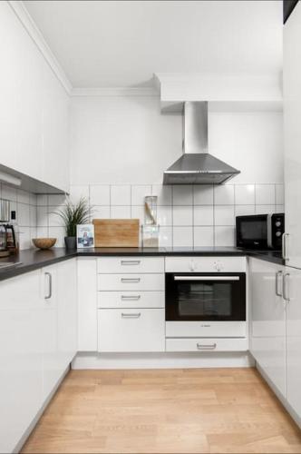 a kitchen with white cabinets and a stove top oven at Øvre Langgate 25 in Tønsberg