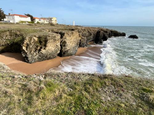 - une plage avec des rochers, l'océan et l'eau dans l'établissement Maison 60 m plage, à Saint-Hilaire-de-Riez