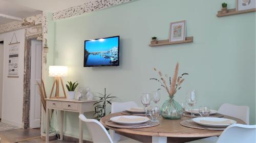 a dining room with a wooden table and white chairs at Blois City - Le Petit Louis XII in Blois