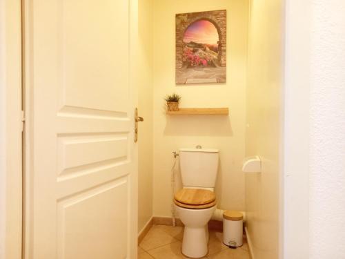une salle de bain avec toilettes et un tableau au mur dans l'établissement T2 de 56m2 - Genève à 5 min- Parking Privé Gratuit, à Saint-Julien-en-Genevois