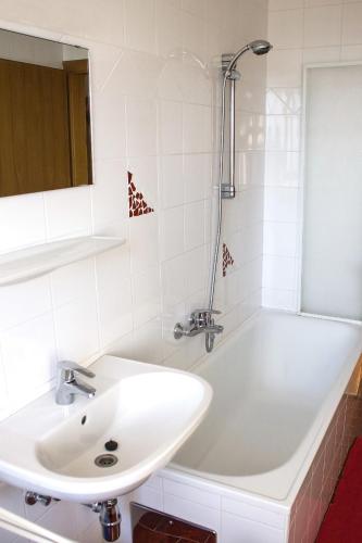 a white bathroom with a sink and a shower at Bauernhof Kronsteiner in Weyregg