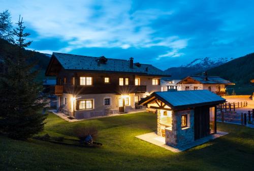 a house with a gazebo in the yard at night at Chalet Rosita in Livigno