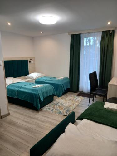 una camera d'albergo con due letti e una finestra di Komfortowe pokoje przy Szymonowica w Krakowie a Cracovia