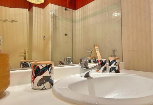 a bathroom with a sink and two cups on a counter at Appartement le Terracotta - Parking - Place du Capitole in Toulouse