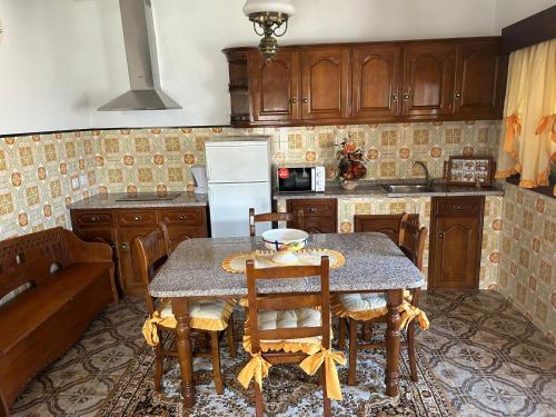 een keuken met een tafel, stoelen en een koelkast bij Casa Encanto do Douro in Várzea do Douro