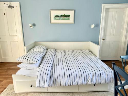 a white bed with two pillows on it in a room at Ballachulish House Apartment in Ballachulish