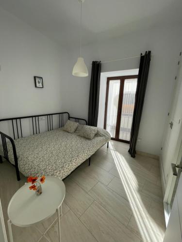 a small bedroom with a bed and a table at Apartamento en pleno centro de Jerez de la Frontera in Jerez de la Frontera