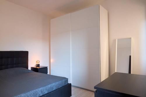 ein Schlafzimmer mit einem Bett und einem großen weißen Schrank in der Unterkunft IL CAMPANILE Apartment in Omegna