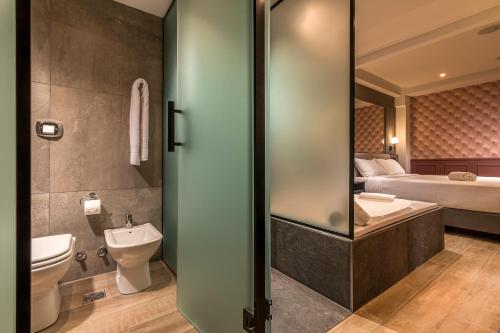 a bathroom with a toilet and a sink and a bed at Up Laprida in Buenos Aires