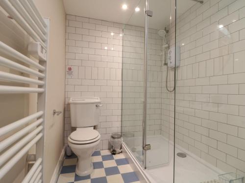 a bathroom with a toilet and a glass shower at Grimes Nook in Staithes