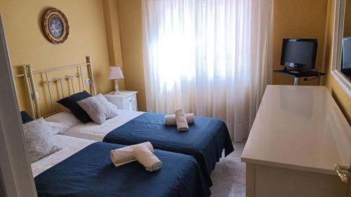 a hotel room with two beds with towels on them at Precioso Apartamento in Peñíscola