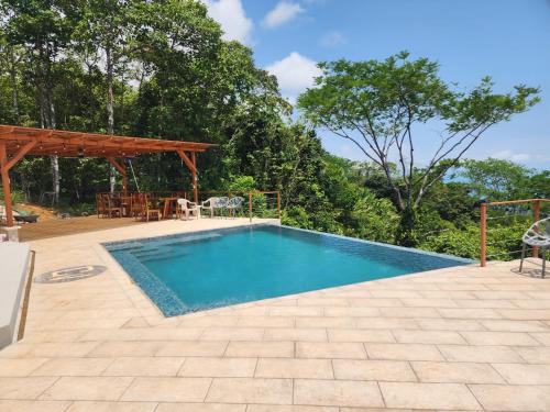 a swimming pool in a backyard with a wooden pergola at Canavida Villas & Resort in Uvita
